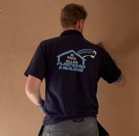 Paul Allen at work skimming a wall, wearing his Paul Allen Plastering & Building polo