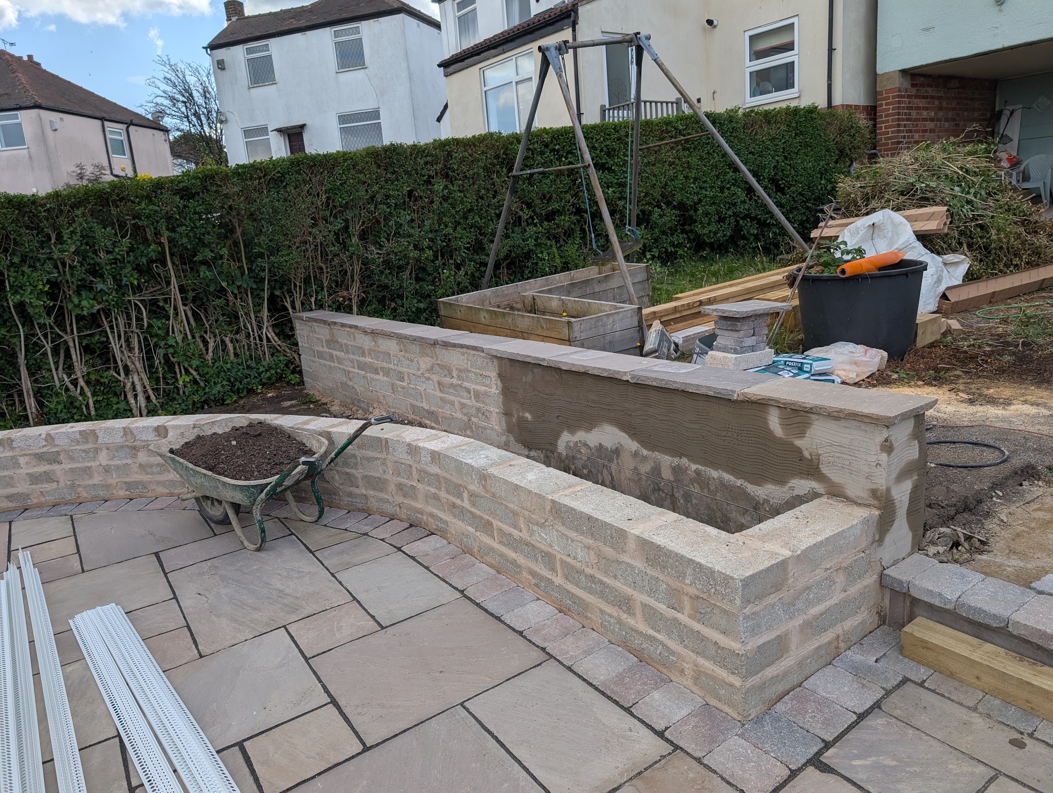 Garden wall part way through being rendered, beside a newly laid patio