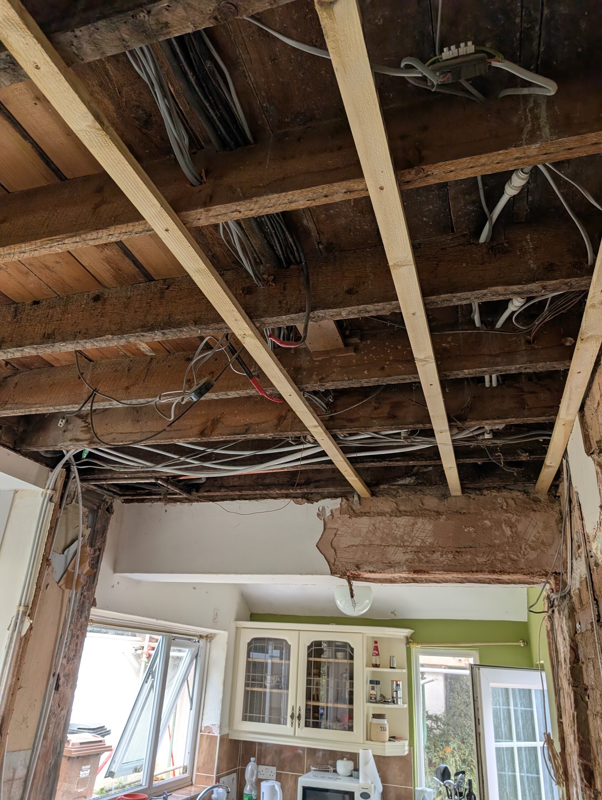 Kitchen ceiling stripped back to the timber joists during a knock-through